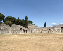 Pompeii Forum with ampitheater in the background, and even further back a little bit of Mt. Vesuvius is visible. Pompeii Forum with ampitheater in the background, and even further back a little bit of Mt. Vesuvius is visible.