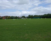 A game of cricket. A one-day test match on the field adjacent to the Tewksbury Abbey.